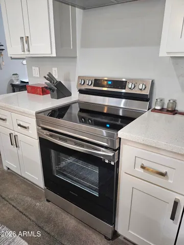 a kitchen with stainless steel appliances granite countertop a refrigerator a stove and a sink