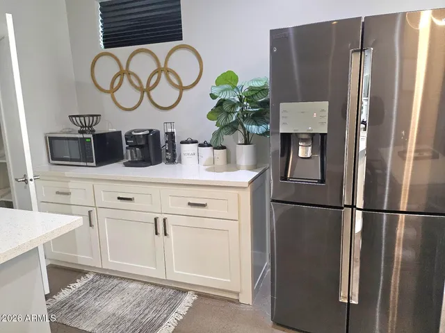 a kitchen with stainless steel appliances a stove a sink a refrigerator a stove and white cabinets