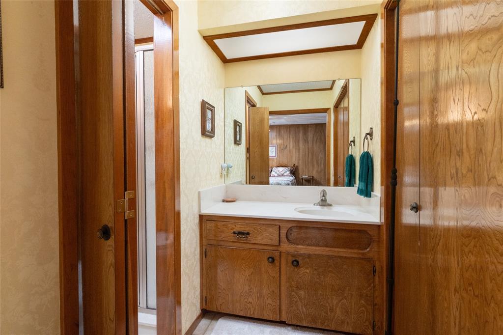 970 Live Oak Road Santo, TX 76472 - Photo 31 of 40 a bathroom with a sink a mirror and a shower