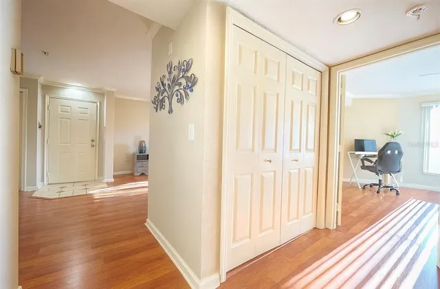 a view of a hallway with wooden floor and a bathroom
