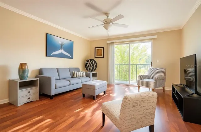 a living room with furniture a flat screen tv and a large window