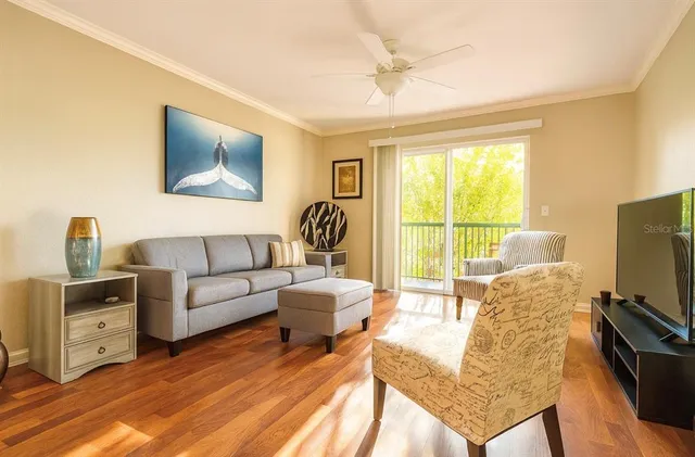 a living room with furniture a flat screen tv and a floor to ceiling window
