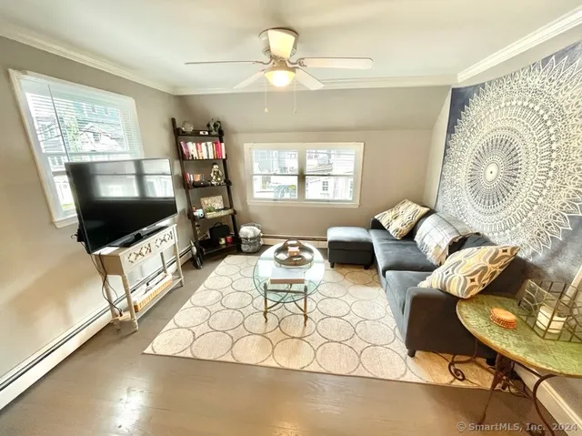 a living room with furniture a flat screen tv and a window