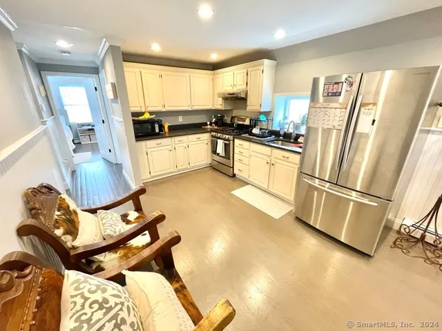 a kitchen with a refrigerator a stove top oven and white cabinets