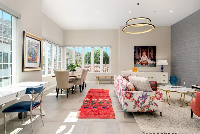 a living room with furniture a flat screen tv and kitchen view
