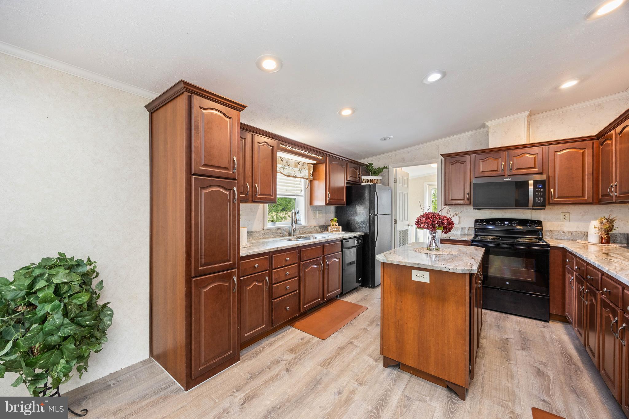 4258 Smith Road Salisbury, MD 21801 - Photo 19 of 43 a kitchen with stainless steel appliances granite countertop a stove top oven a sink dishwasher and a refrigerator with wooden floor