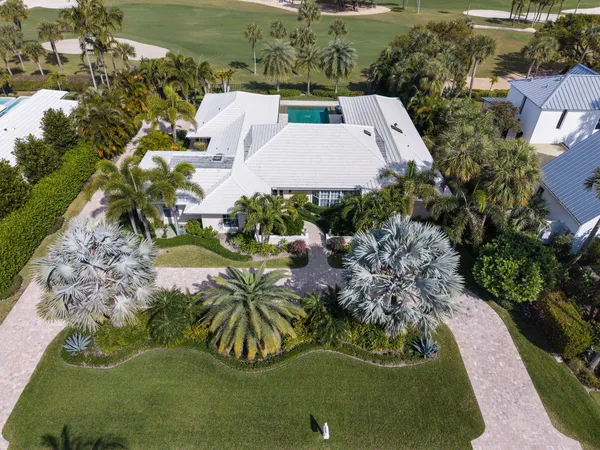 an aerial view of a house with garden space and lake view