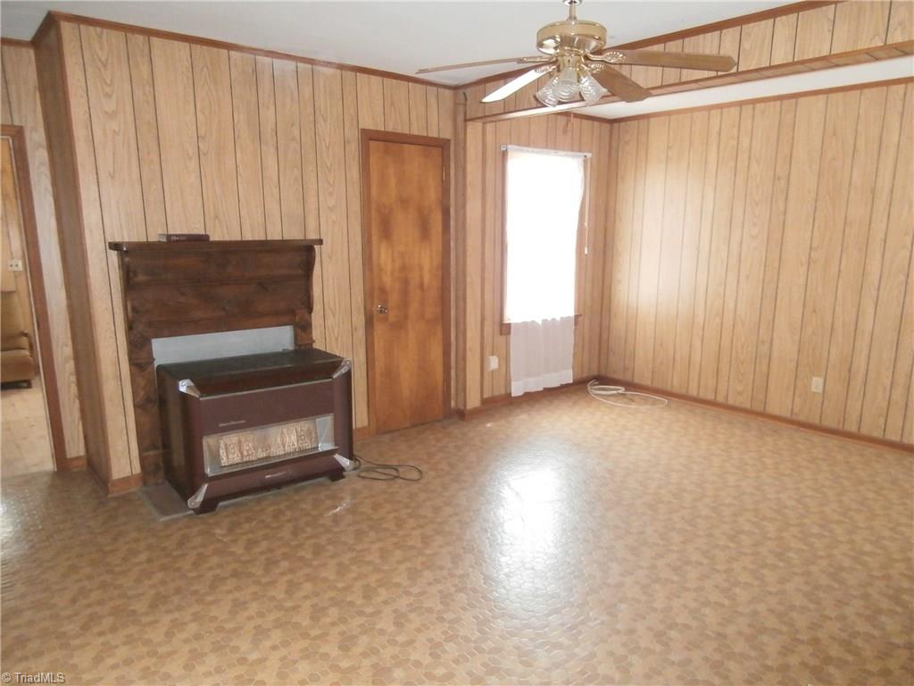486 Jerry Frye Road Bennett, NC 27208 - Photo 4 of 16 Living Room. Freestanding Gas Stove. Vinly. Paneled.
