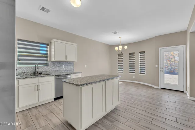 a kitchen with granite countertop a sink and a stove top oven