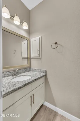 a bathroom with a granite countertop sink and mirror