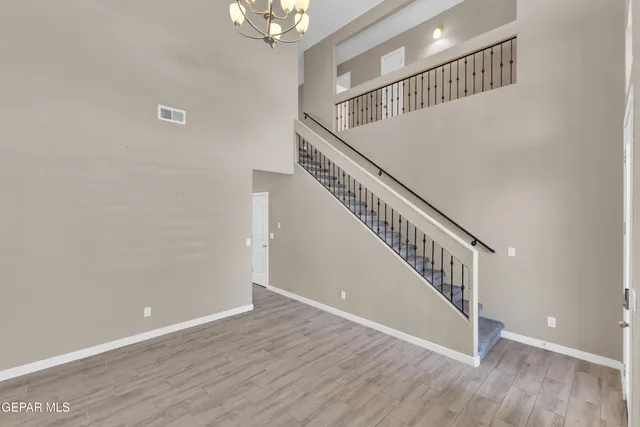 a view of staircase with wooden floor and fan