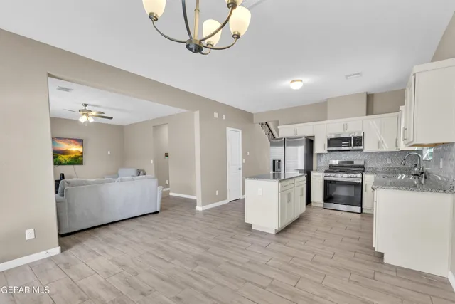 a kitchen with a refrigerator and a stove top oven