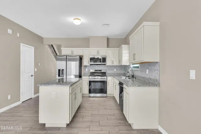 a kitchen with stainless steel appliances granite countertop a stove and a sink
