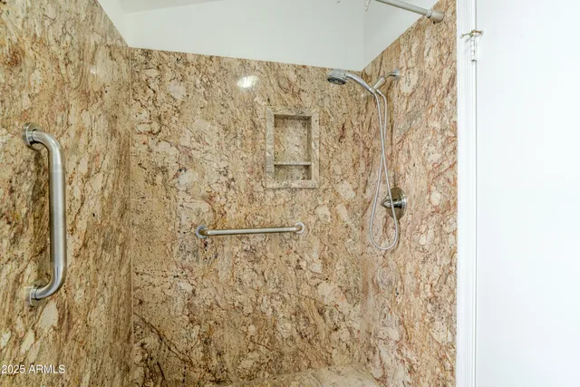 a bathroom with a sink a toilet a mirror and shower