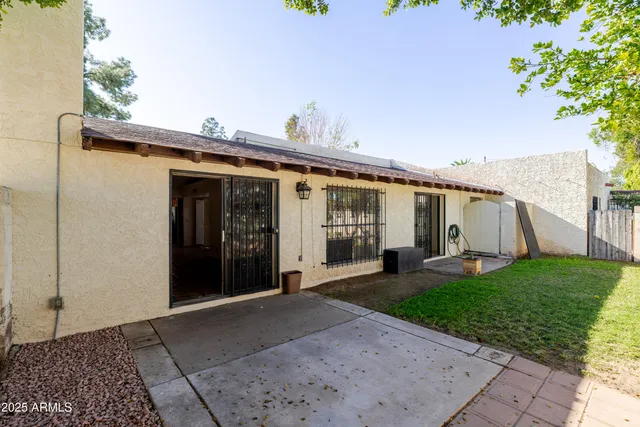 a view of a patio with couches table and chairs under an umbrella