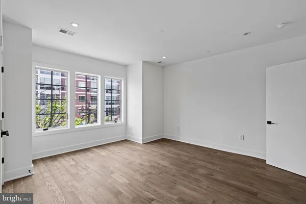 a view of empty room with wooden floor