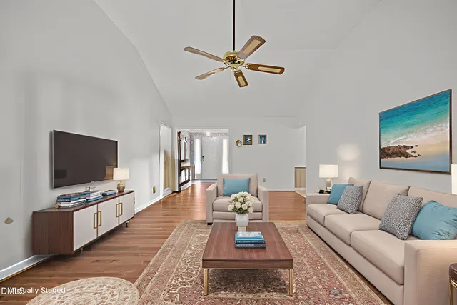 a view of a livingroom with furniture a fireplace wooden floor and chandelier