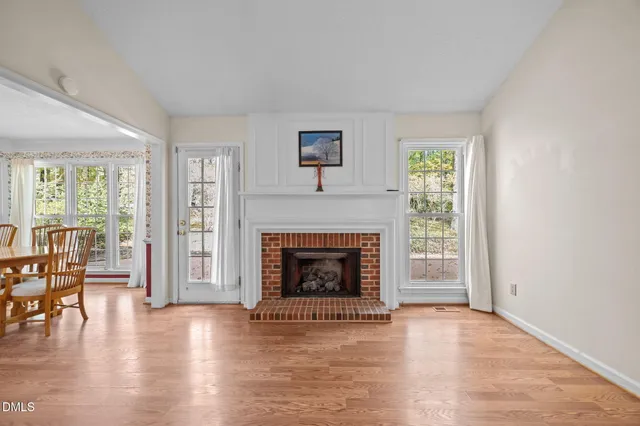 an empty room with windows and fireplace