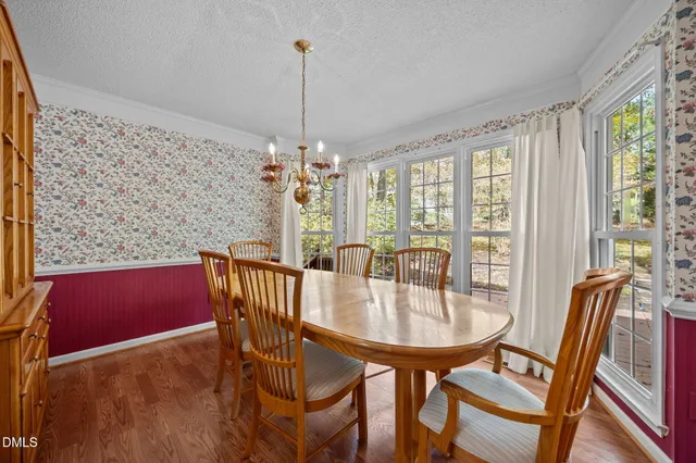 a dining room with furniture a chandelier and wooden floor