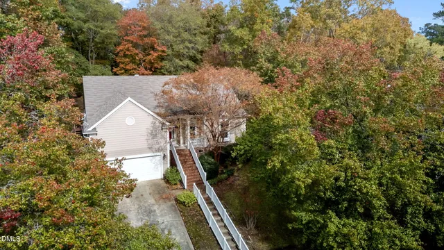 an aerial view of residential houses with outdoor space and trees