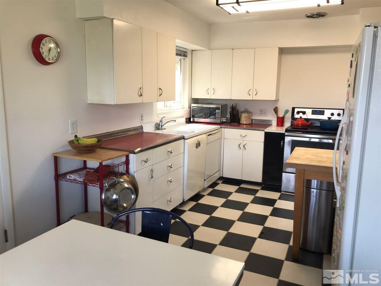 1205 Wilkinson Avenue Reno, NV 89502 - Photo 3 of 17 a kitchen with stainless steel appliances a sink a stove a refrigerator and white cabinets with wooden floor