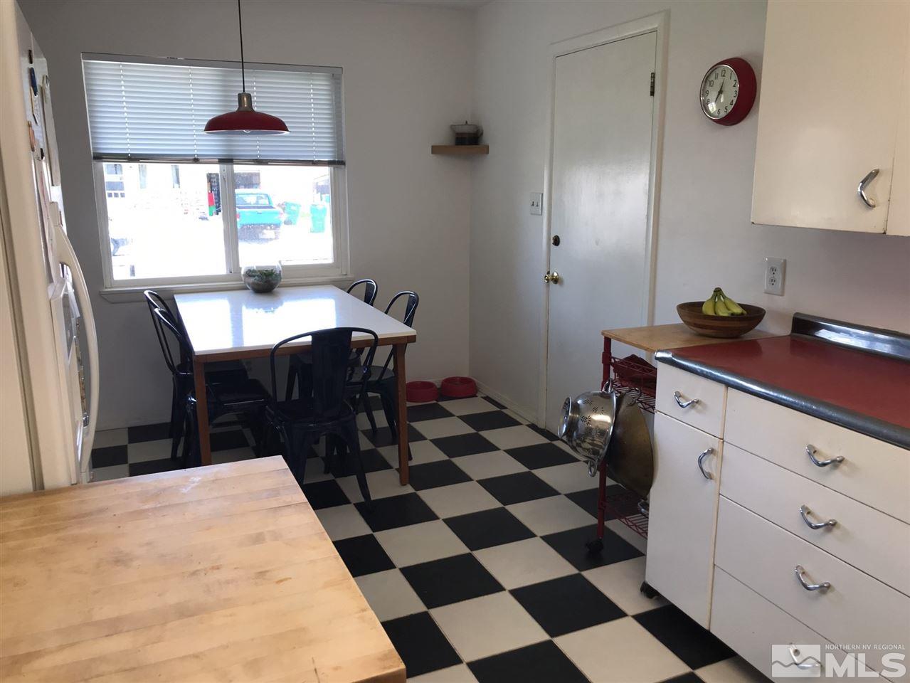 1205 Wilkinson Avenue Reno, NV 89502 - Photo 4 of 17 a kitchen with a sink a stove a dining table and a black white checkered floor