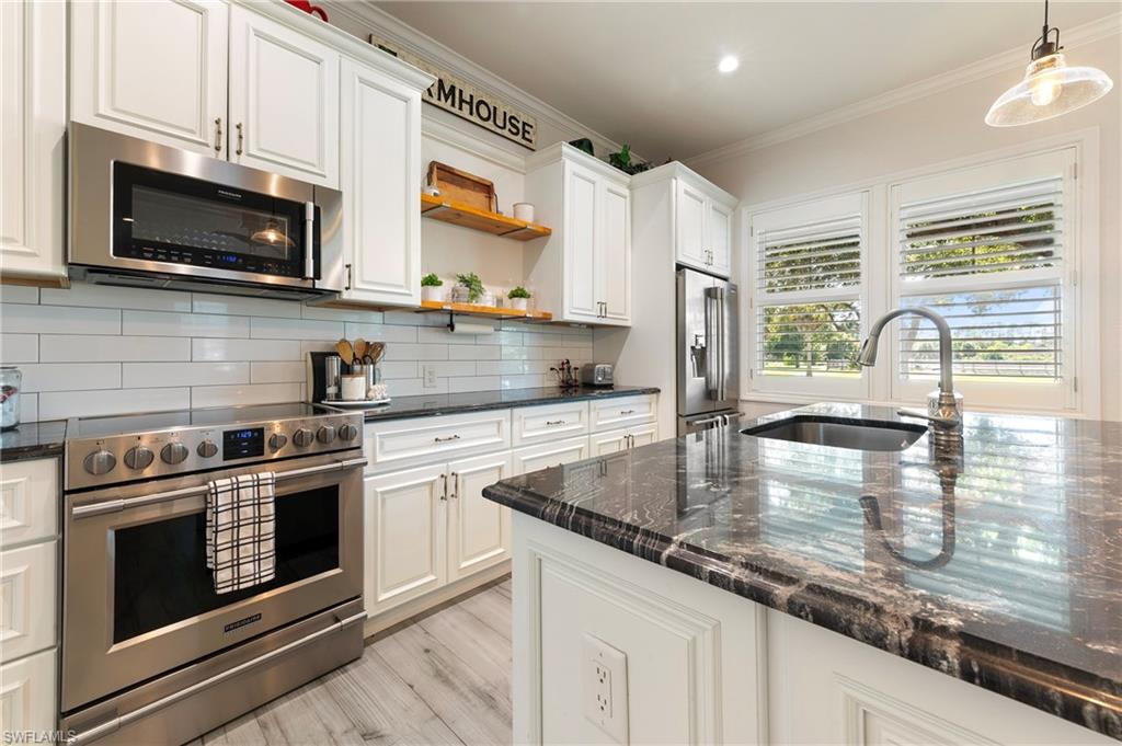 10910 Ruden Road North Fort Myers, FL 33917 - Photo 25 of 48 a kitchen with stainless steel appliances granite countertop a stove microwave and sink