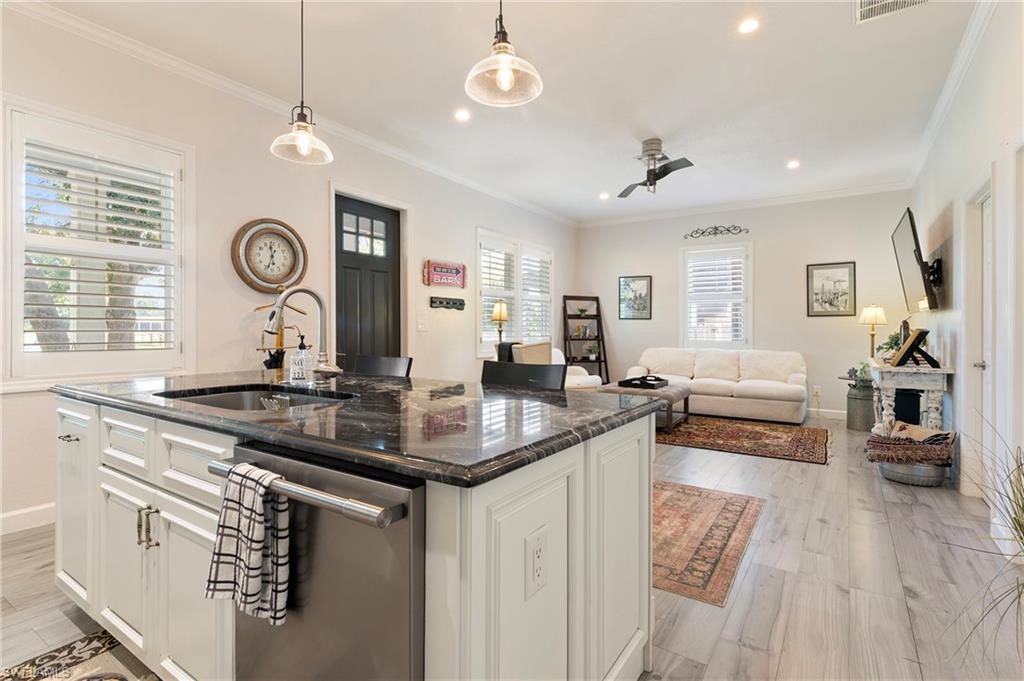 10910 Ruden Road North Fort Myers, FL 33917 - Photo 26 of 48 a kitchen with stainless steel appliances granite countertop a stove a sink a dining table and chairs with wooden floor