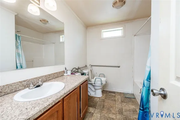 a bathroom with a granite countertop sink a mirror and a toilet