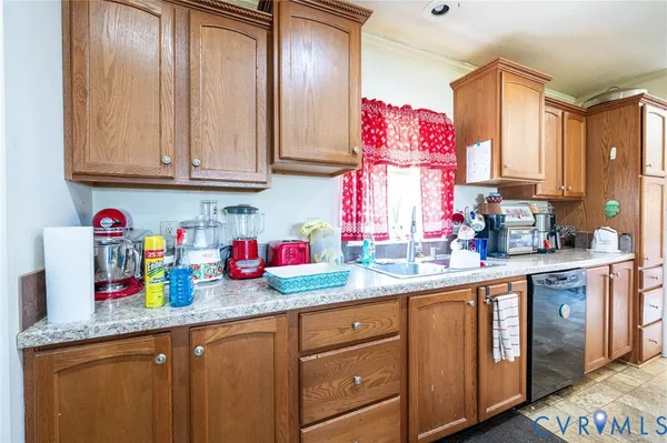 a kitchen with granite countertop a sink stainless steel appliances wooden cabinets and a window
