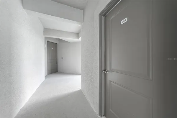 a view of a hallway with wooden floor and a window