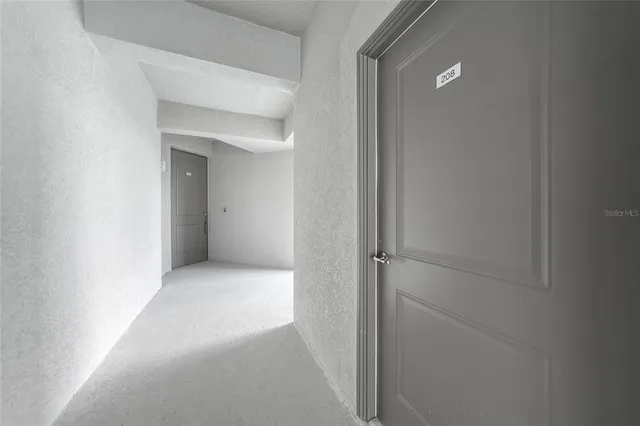 a view of a hallway with wooden floor and a window
