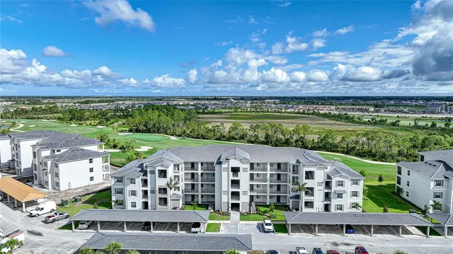 a view of a big building with a big yard and large trees