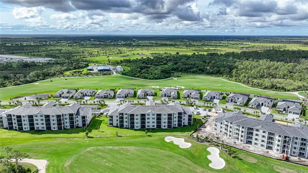 a view of a swimming pool with lawn chairs and plants