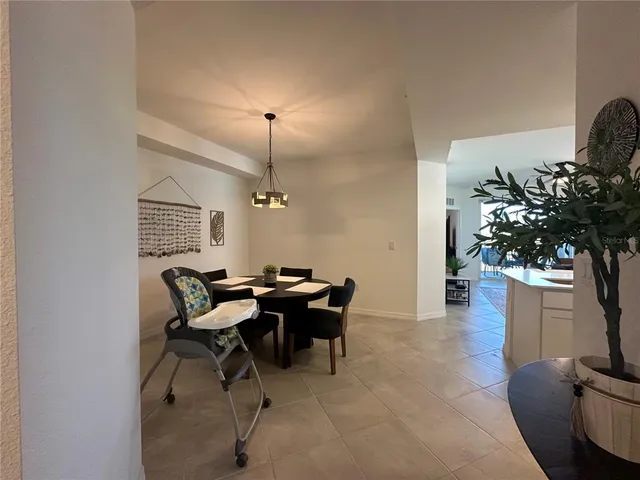 a view of a room that has a chandelier and a table in it