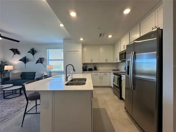 a kitchen with a dining table chairs and refrigerator