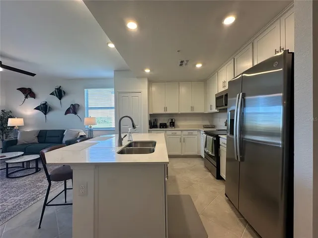 a kitchen with a dining table chairs and refrigerator