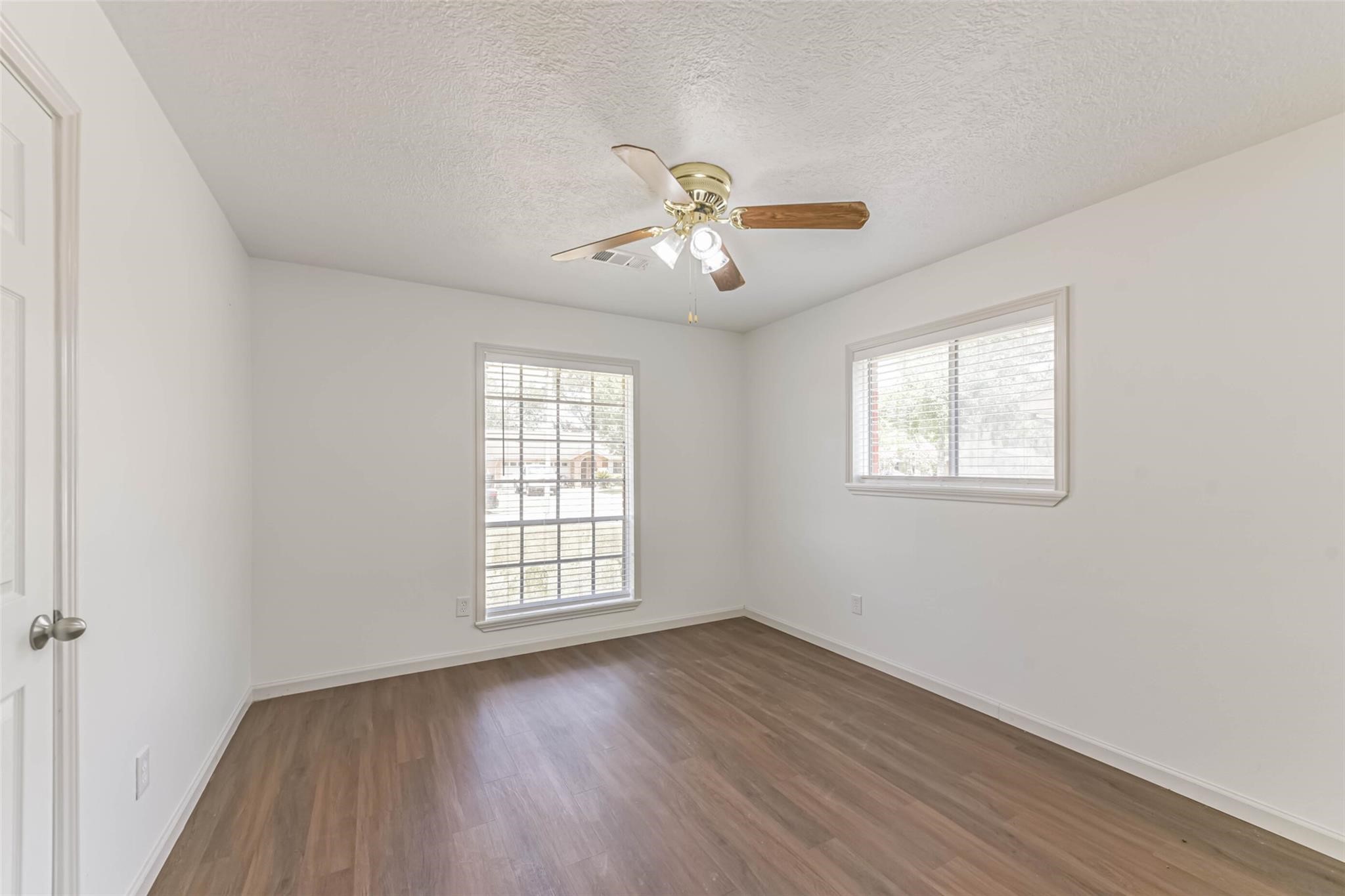 12002 Palmcroft Street Houston, TX 77034 - Photo 12 of 16 a view of empty room with wooden floor and fan