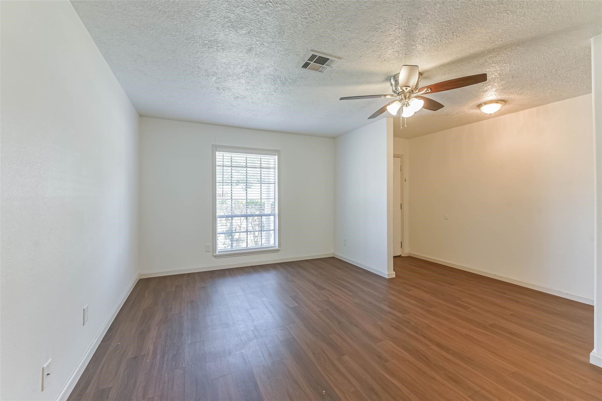 12002 Palmcroft Street Houston, TX 77034 - Photo 4 of 16 a view of empty room with wooden floor and fan
