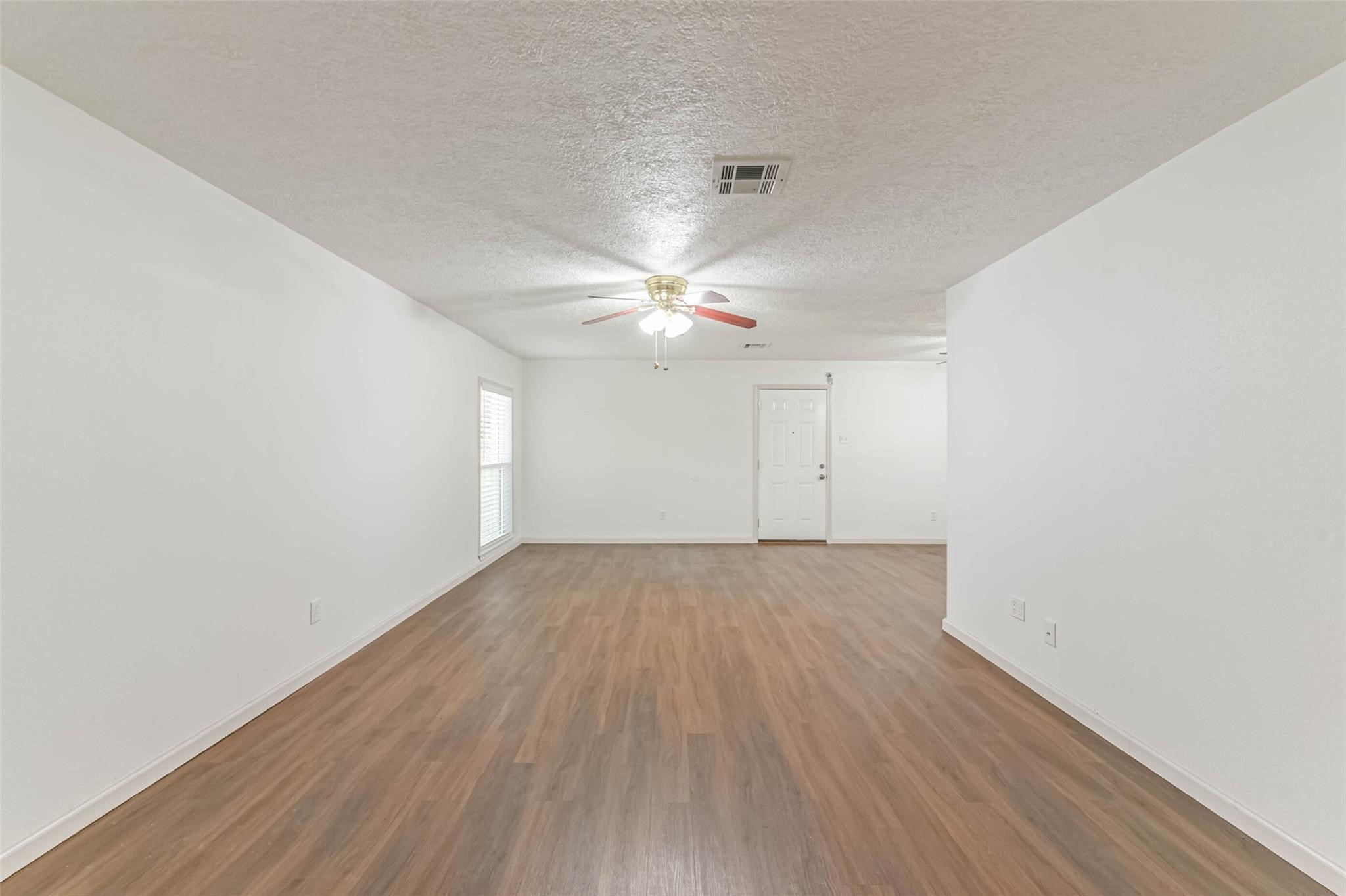 12002 Palmcroft Street Houston, TX 77034 - Photo 5 of 16 an empty room with wooden floor and windows