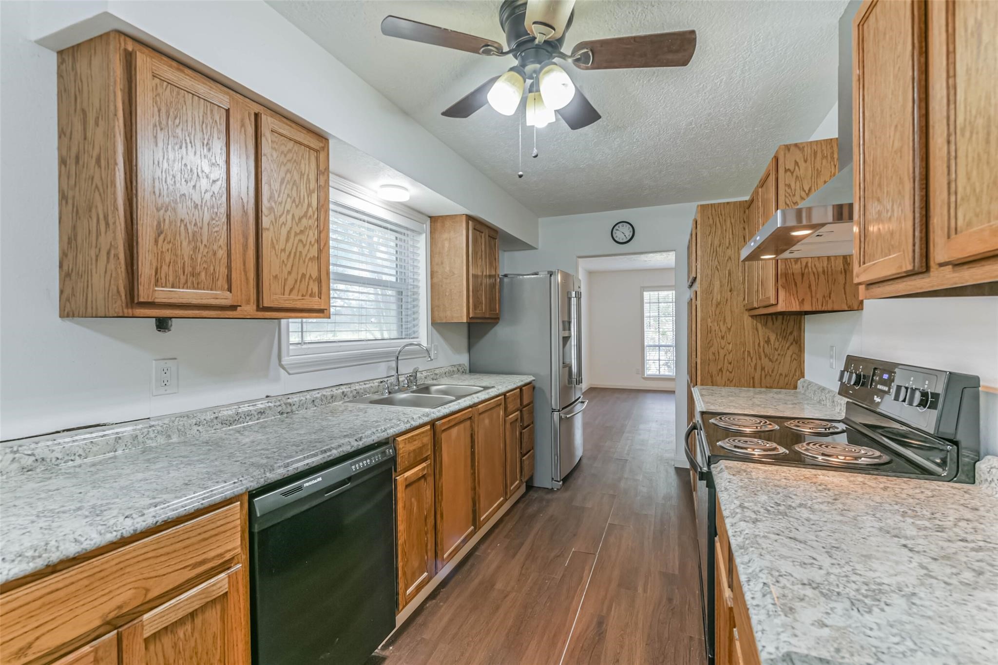 12002 Palmcroft Street Houston, TX 77034 - Photo 8 of 16 a kitchen with stainless steel appliances granite countertop wooden cabinets a stove top oven a sink and dishwasher