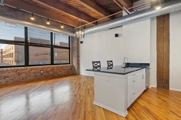 a kitchen with granite countertop a sink and a wooden floor