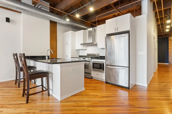 a kitchen with stainless steel appliances a refrigerator a stove top oven and cabinets