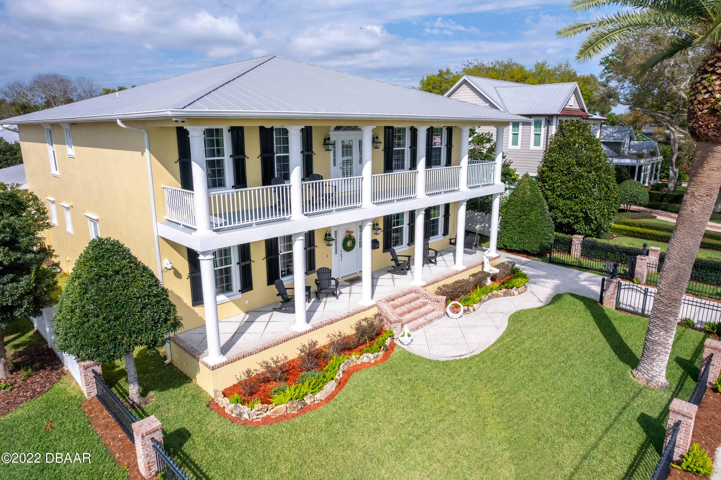 an aerial view of a house with swimming pool and chairs