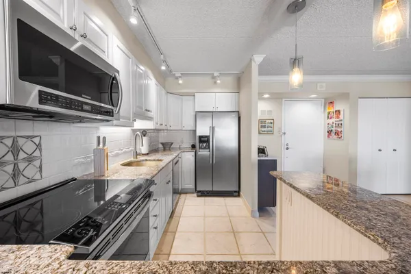 a kitchen with stainless steel appliances kitchen island granite countertop a stove and a sink