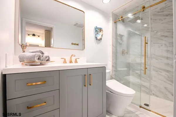 a bathroom with a sink a toilet and shower