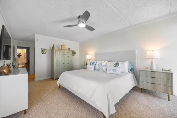 a bedroom with a large bed and a chandelier