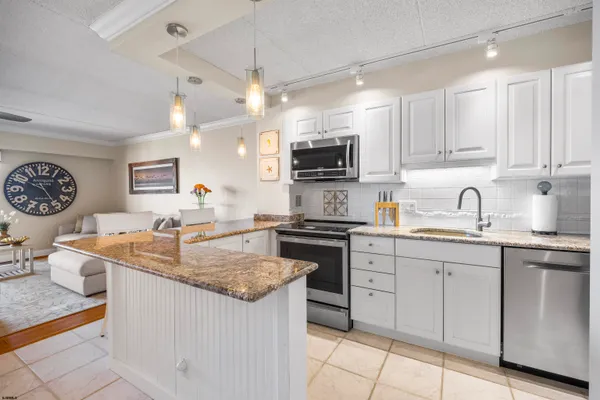 a kitchen with kitchen island granite countertop a sink cabinets and stainless steel appliances