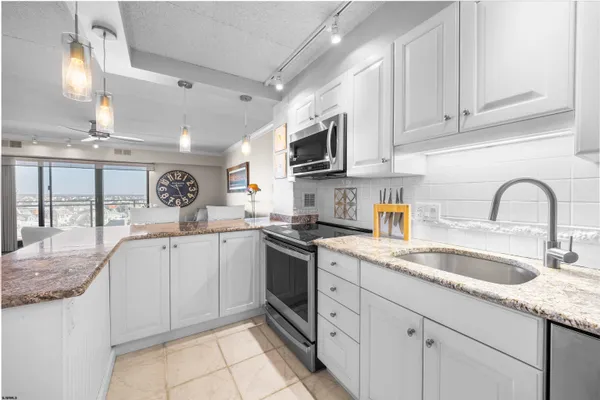 a kitchen with granite countertop a sink stainless steel appliances and cabinets