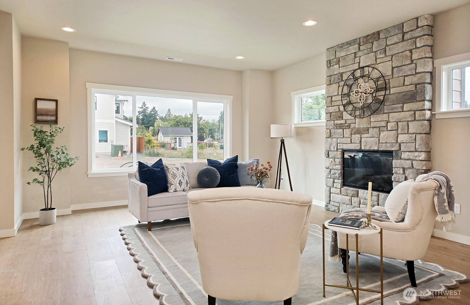695 3rd Street, Unit B Langley, WA 98260 - Photo 4 of 28 a living room with furniture a fireplace and a floor to ceiling window